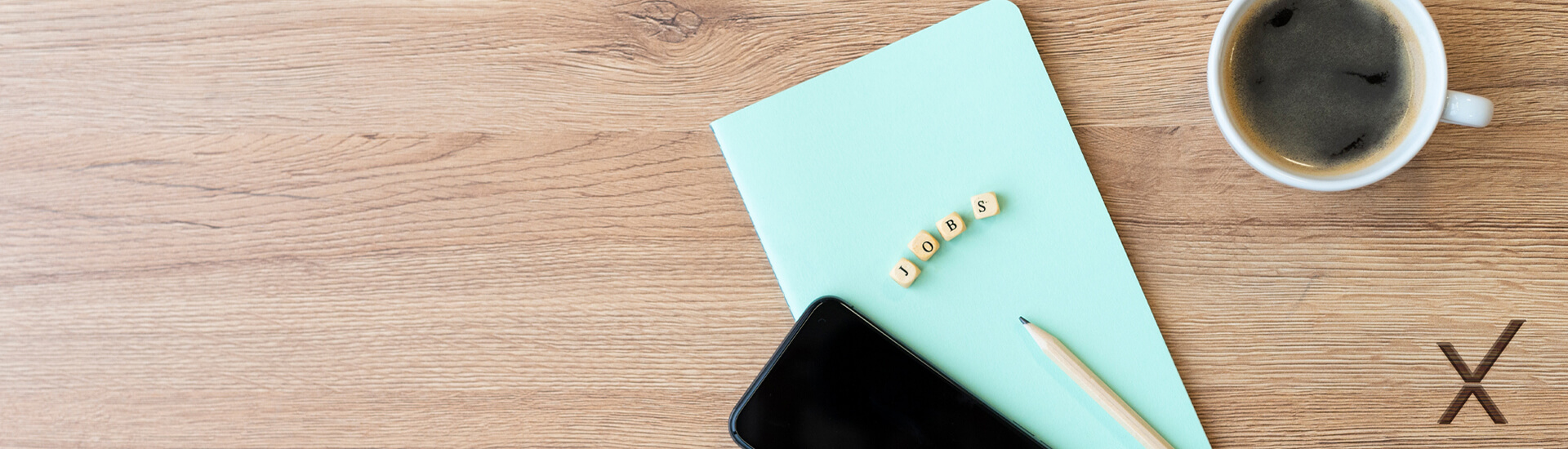 Kaffeetasse, Schreibblock, Smartphone und Bleistift